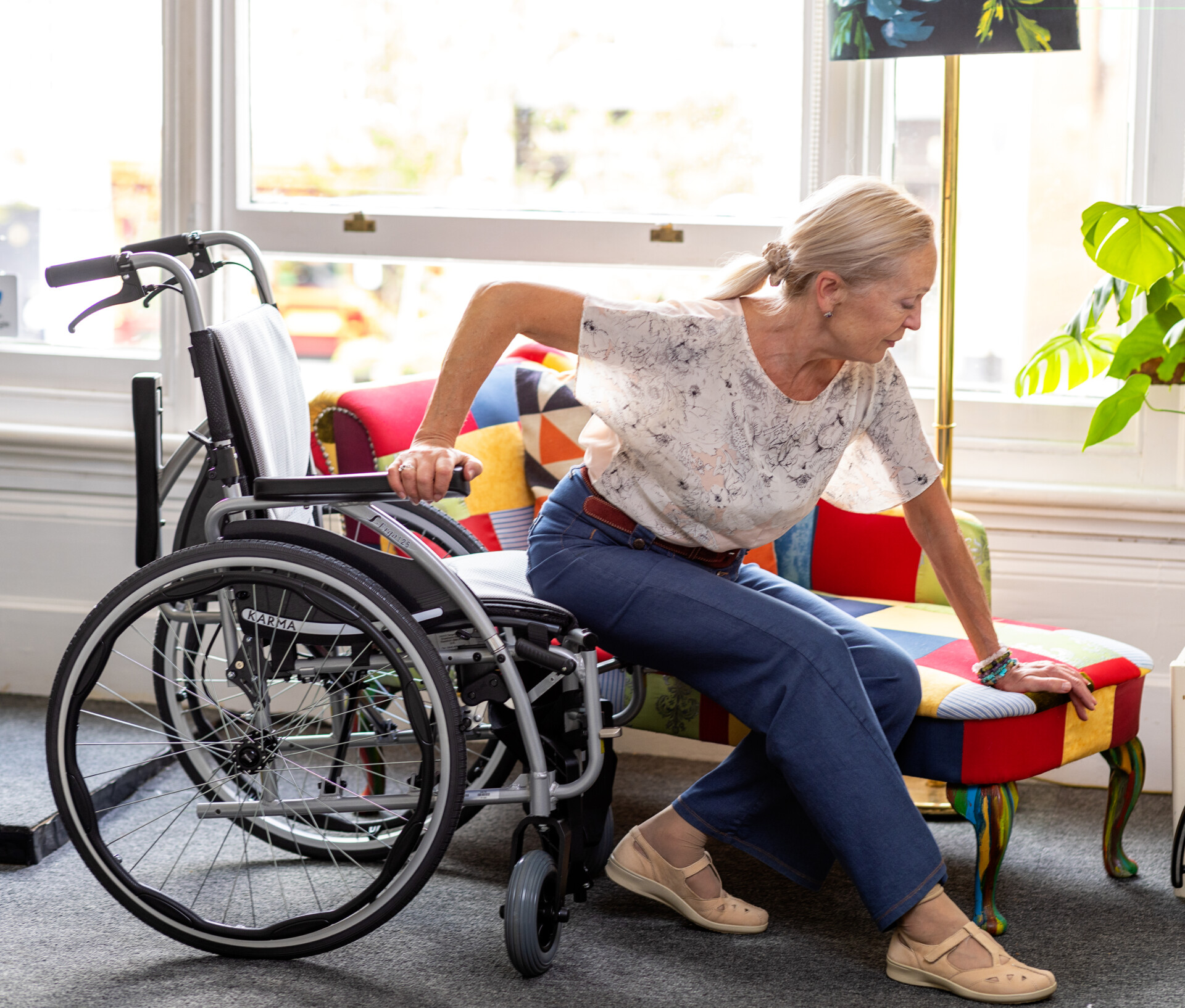  An elder is moving from a transfer wheelchair to the sofa.