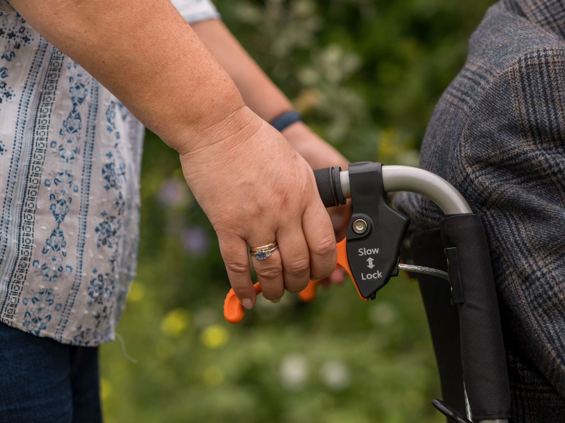 A-caregiver-demonstrating-the-push-and-pull-brakes-function-of-a-manual-wheelchair