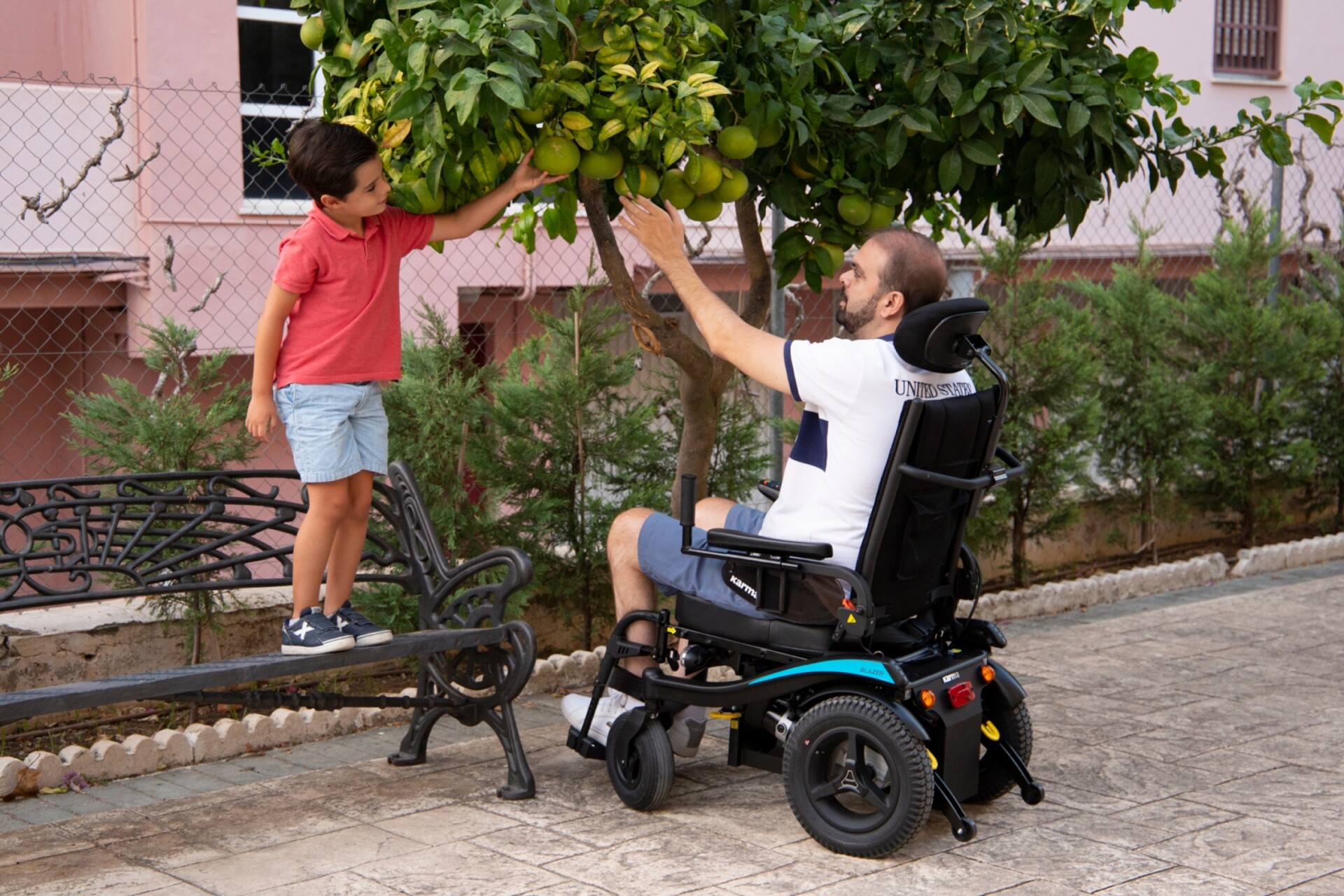 A man in a wheelchair engaging in outdoor activities with a child.