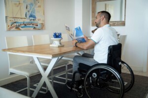 a-man-in-a-wheelchair-reading-a-brochure-at-a-table-indoor