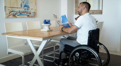 a-man-in-a-wheelchair-reading-a-brochure-at-a-table-indoor